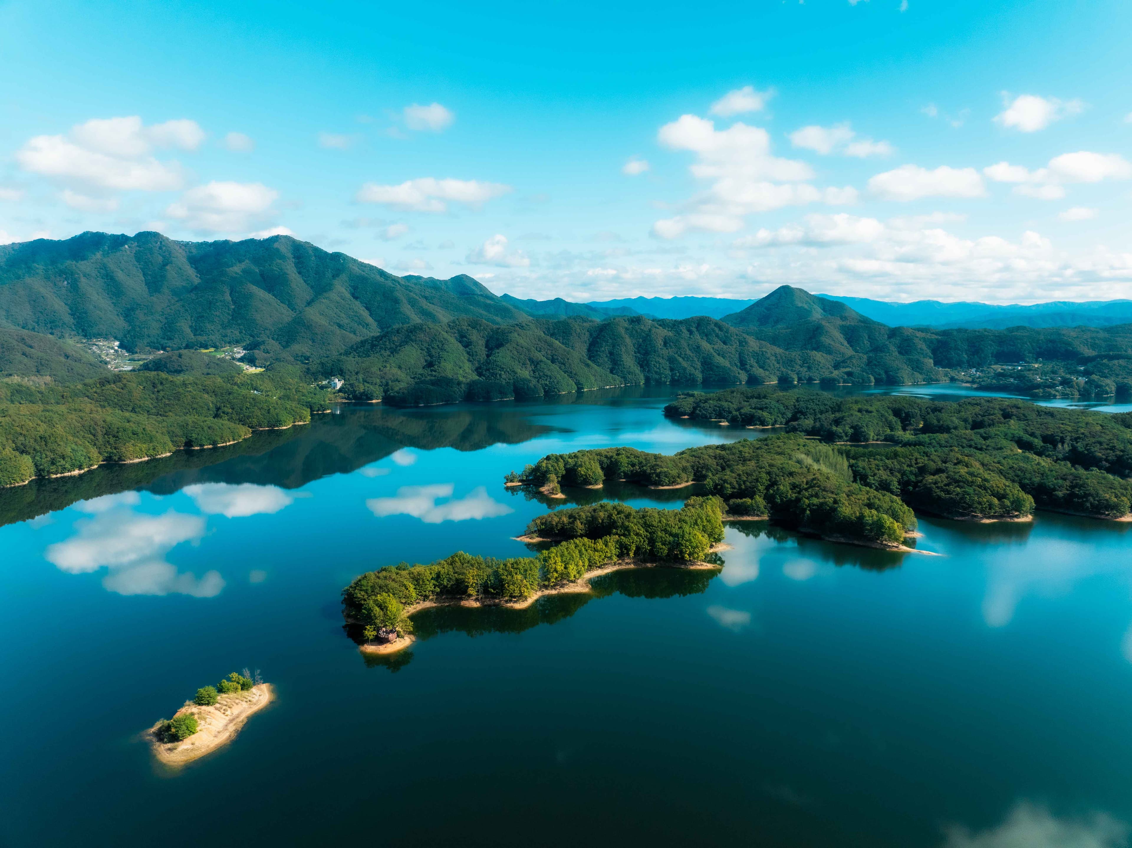 Forested islands in deep blue water along the Hoengseonghosugil trail in Hoengseong.