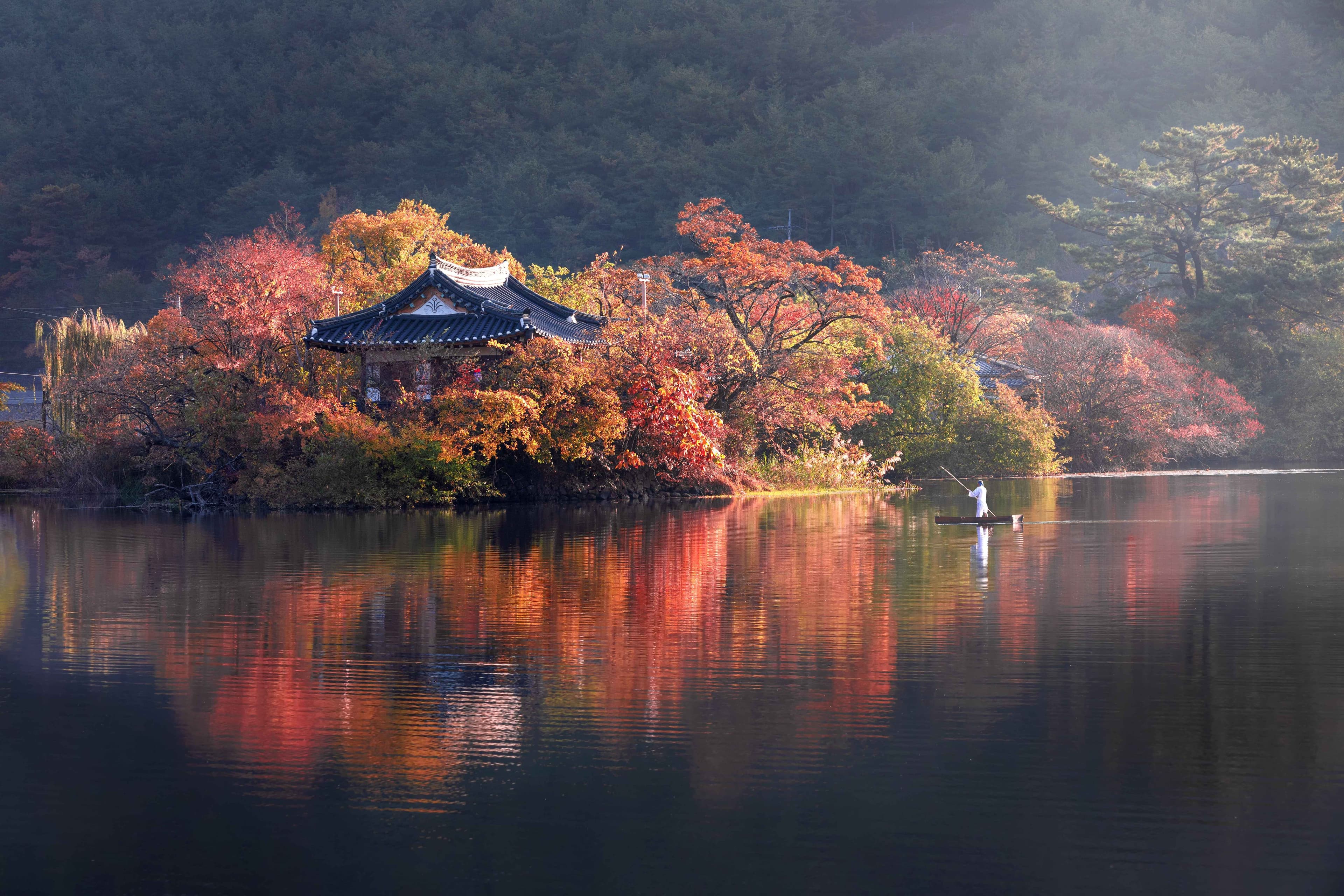 Autumn trees reflected across Wiyang Pond in Miryang.